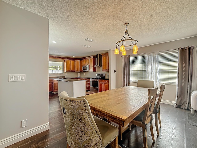 dining space featuring dark wood-type flooring, visible vents, a textured ceiling, and baseboards