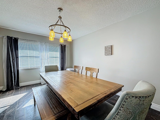 dining space featuring a textured ceiling, dark wood-type flooring, and baseboards