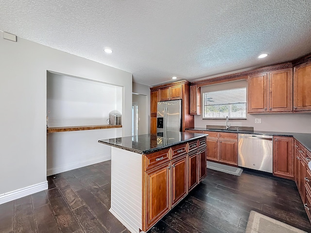 kitchen featuring stainless steel appliances, dark wood-style flooring, brown cabinetry, and a sink