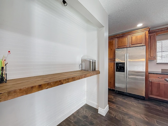 kitchen with brown cabinets, dark wood finished floors, stainless steel refrigerator with ice dispenser, butcher block counters, and a textured ceiling