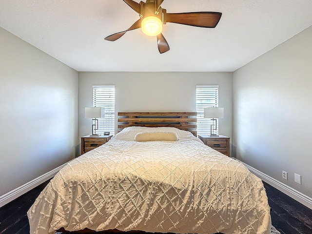 bedroom with dark wood-style flooring, a ceiling fan, and baseboards