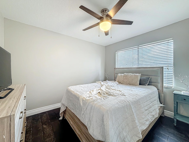 bedroom featuring dark wood-style floors, ceiling fan, baseboards, and a textured ceiling