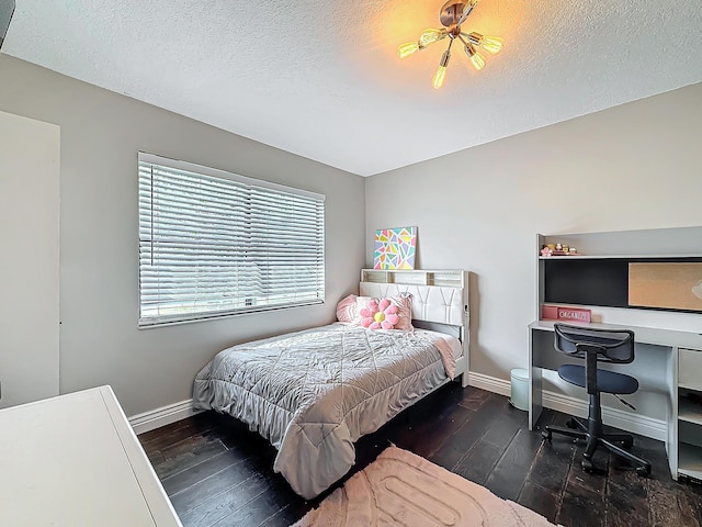 bedroom featuring a textured ceiling, baseboards, and wood finished floors