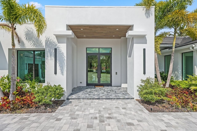 property entrance featuring french doors and stucco siding