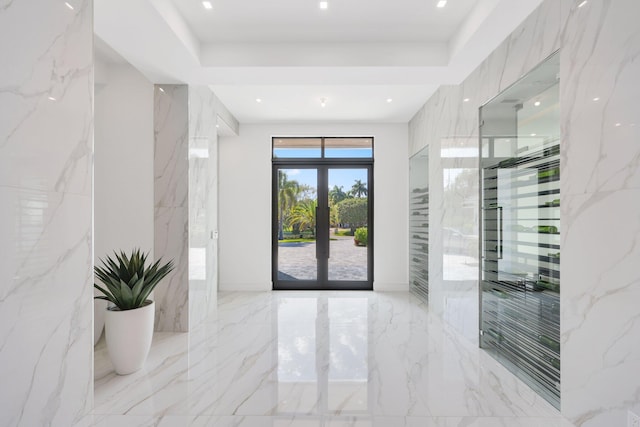 foyer featuring marble finish floor, stone wall, french doors, and recessed lighting