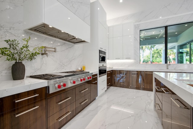 kitchen featuring modern cabinets, appliances with stainless steel finishes, custom exhaust hood, white cabinetry, and a sink