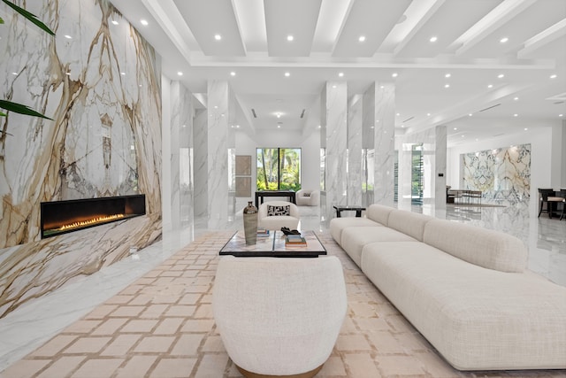 living room with stone wall, a high end fireplace, beam ceiling, and recessed lighting