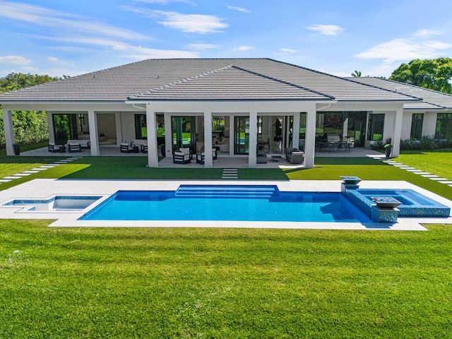 view of pool featuring a pool with connected hot tub, a lawn, and a patio