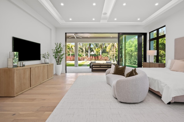 bedroom featuring access to outside, a raised ceiling, light wood finished floors, and recessed lighting