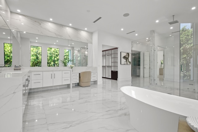 full bath with recessed lighting, marble finish floor, visible vents, and stone wall