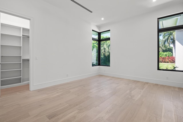 empty room with recessed lighting, light wood-style flooring, and baseboards