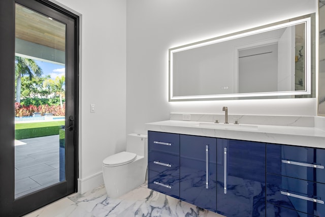 bathroom featuring toilet, marble finish floor, baseboards, and vanity