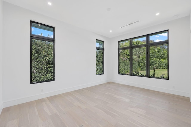 spare room with recessed lighting, light wood-type flooring, visible vents, and baseboards