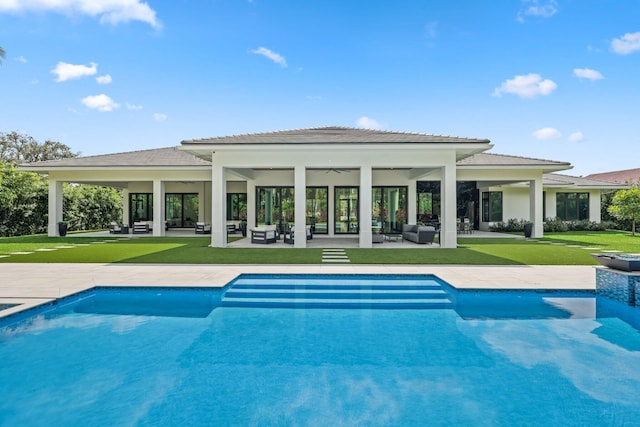 pool featuring a patio area, outdoor lounge area, a ceiling fan, and a yard