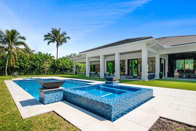 view of swimming pool featuring a yard, a patio area, and a pool with connected hot tub