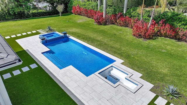 view of swimming pool with a pool with connected hot tub, a patio area, and a yard