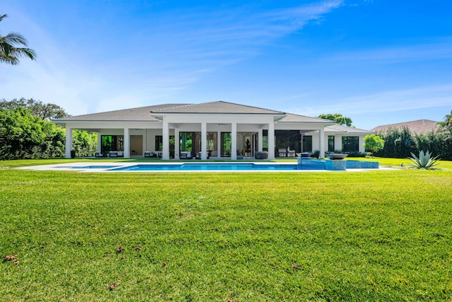 back of property featuring an outdoor pool and a lawn