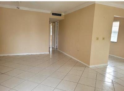 spare room with visible vents, crown molding, and baseboards