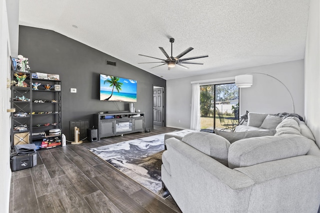 living room featuring visible vents, lofted ceiling, dark wood-style floors, a textured ceiling, and a ceiling fan