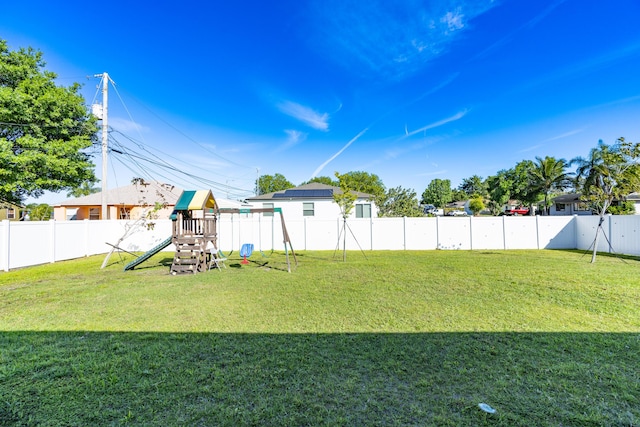 view of yard with a playground and a fenced backyard