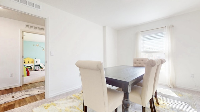 dining area featuring wood finished floors, visible vents, and baseboards