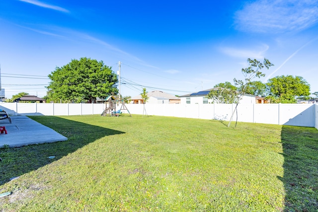 view of yard with a patio area, a playground, and a fenced backyard