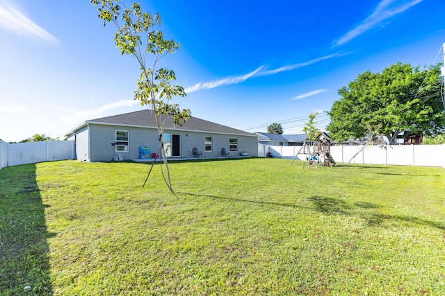 view of yard with a playground and a fenced backyard