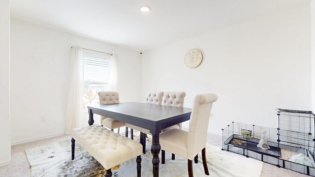 carpeted dining area with baseboards