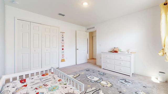 carpeted bedroom with a closet and visible vents