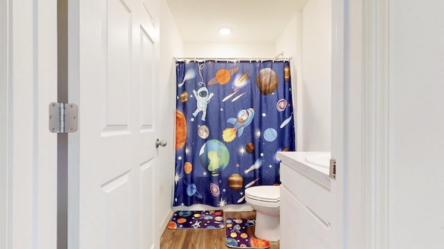 full bath featuring vanity, a shower with shower curtain, wood finished floors, and toilet