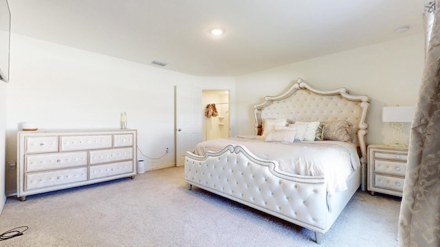 carpeted bedroom with visible vents and connected bathroom