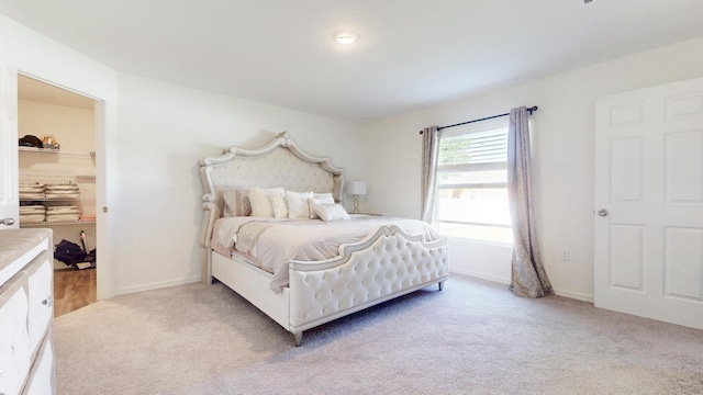 bedroom with light colored carpet and baseboards