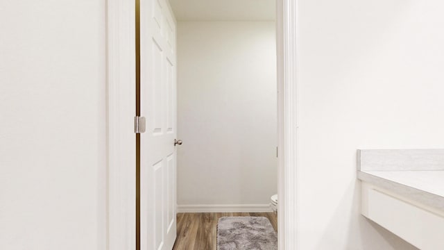 bathroom with baseboards, vanity, toilet, and wood finished floors