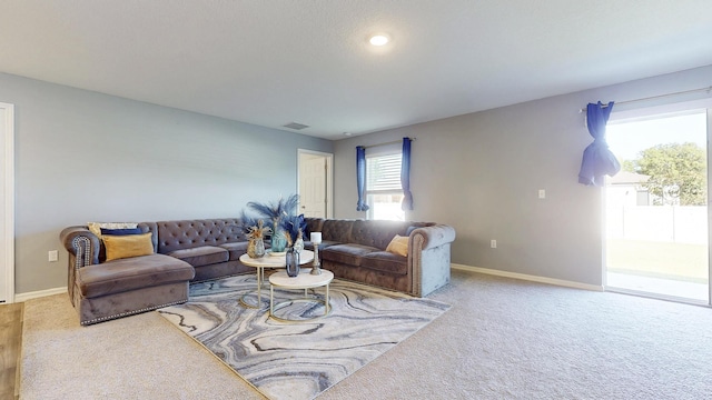 living room with carpet flooring, visible vents, and a healthy amount of sunlight