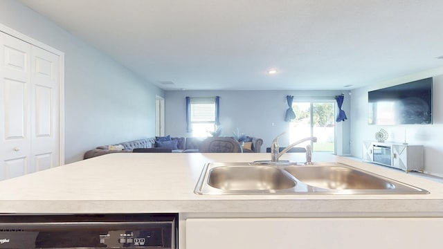 kitchen with dishwasher, open floor plan, a sink, and a wealth of natural light