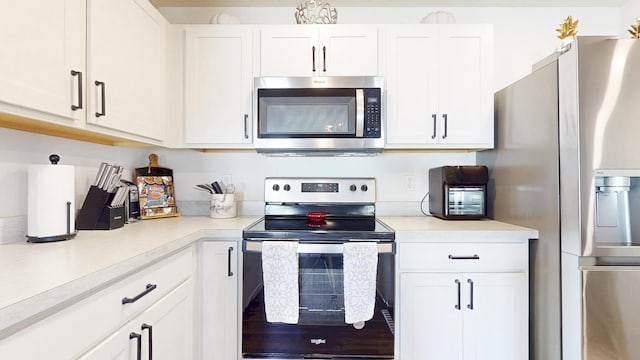 kitchen featuring light countertops, appliances with stainless steel finishes, and white cabinetry