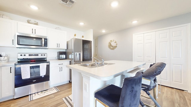 kitchen with visible vents, appliances with stainless steel finishes, light countertops, light wood-style floors, and a sink