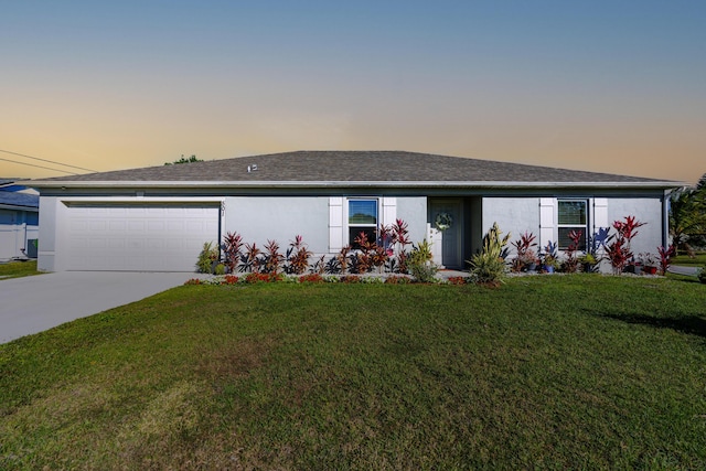 ranch-style house with driveway, a lawn, an attached garage, and stucco siding