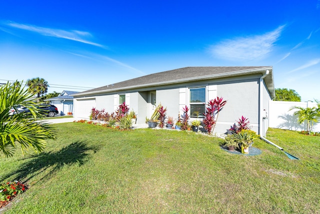 view of front of home with a garage, fence, concrete driveway, stucco siding, and a front lawn