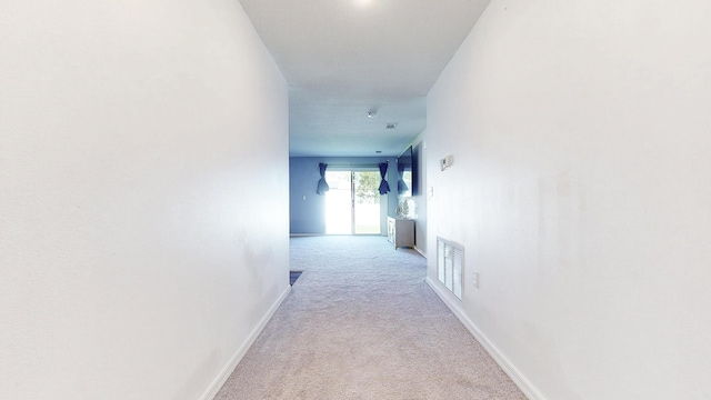 corridor with carpet flooring, visible vents, and baseboards