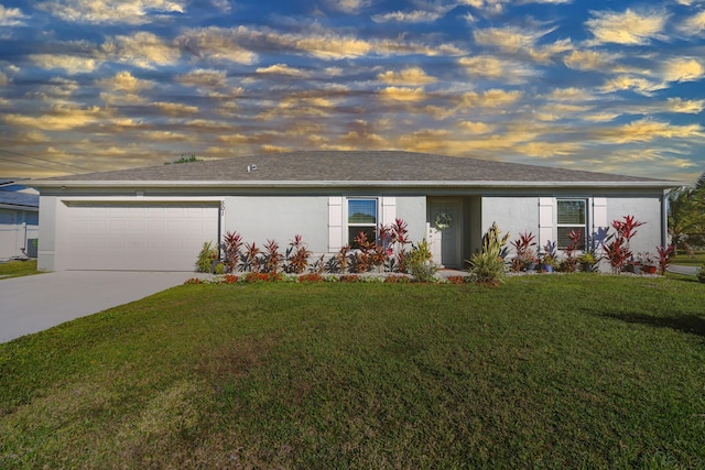 ranch-style house with an attached garage, a yard, concrete driveway, roof with shingles, and stucco siding