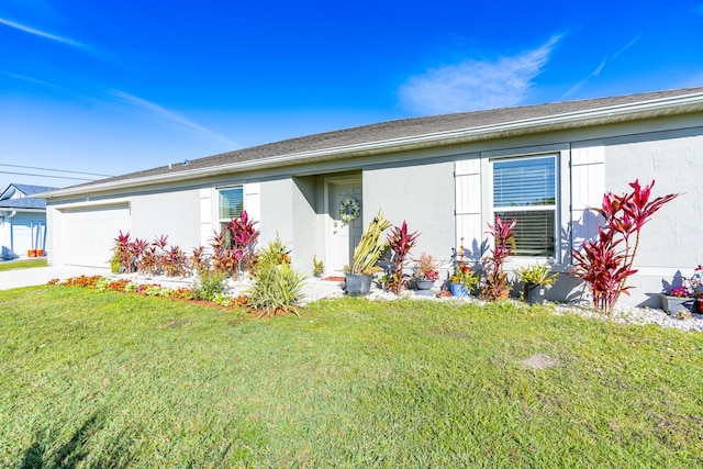 ranch-style house featuring a front yard, driveway, an attached garage, and stucco siding