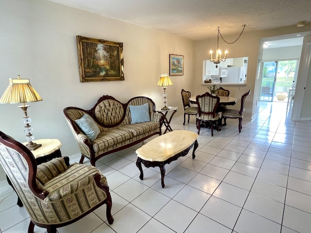 living room with light tile patterned floors, a textured ceiling, baseboards, and an inviting chandelier