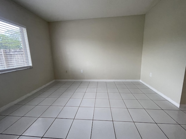 unfurnished room with baseboards and light tile patterned floors