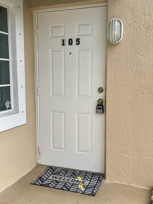 view of exterior entry featuring stucco siding