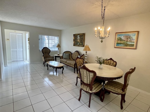 dining space featuring a textured ceiling, light tile patterned flooring, baseboards, and an inviting chandelier