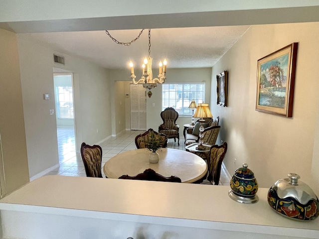 dining area with an inviting chandelier, baseboards, visible vents, and light tile patterned flooring