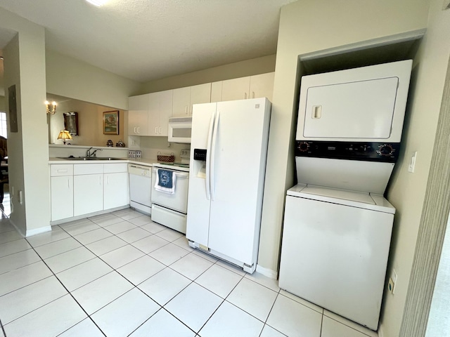 kitchen featuring light countertops, stacked washer / dryer, white cabinetry, a sink, and white appliances