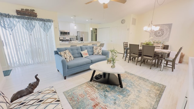 living area featuring visible vents and ceiling fan with notable chandelier