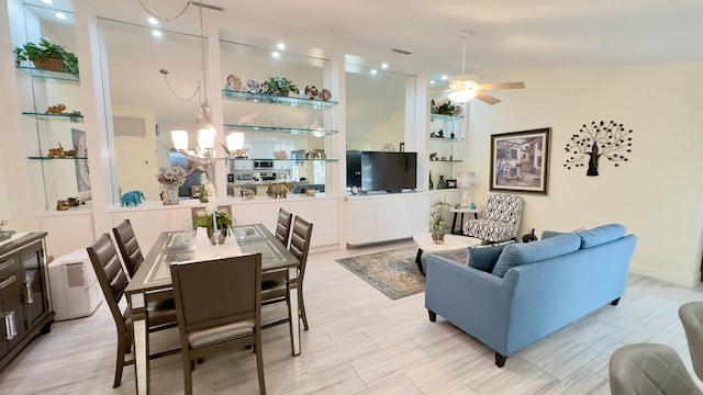 living area with ceiling fan with notable chandelier